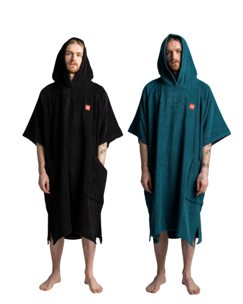 Two people wearing hooded changing towel ponchos, one black and one teal, on a white background.