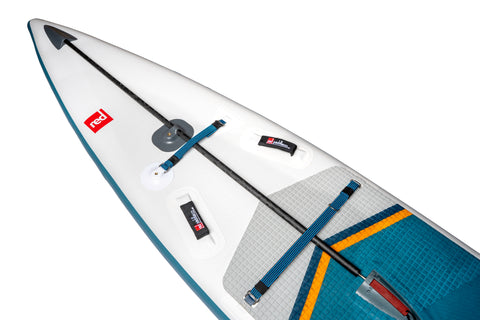 Close up image of the front section of a white paddleboard with attachment points, handles and brand logos.