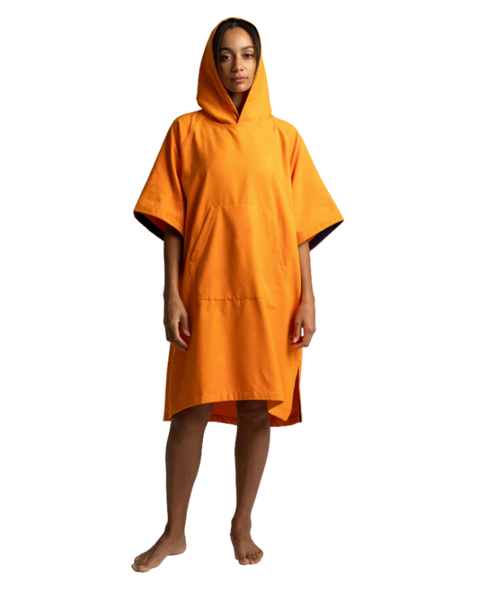 Person wearing an orange hooded changing poncho on a white background