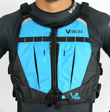 A person wearing a cyan and black Vaikobi V4 PFD Vest for Ocean Paddling. The vest is visible over the person's long sleeve top, showcasing the front pockets.