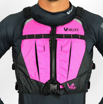 A person wearing a pink and black Vaikobi V4 PFD Vest for Ocean Paddling. The vest is visible over the person's long sleeve top, showcasing the front pockets.